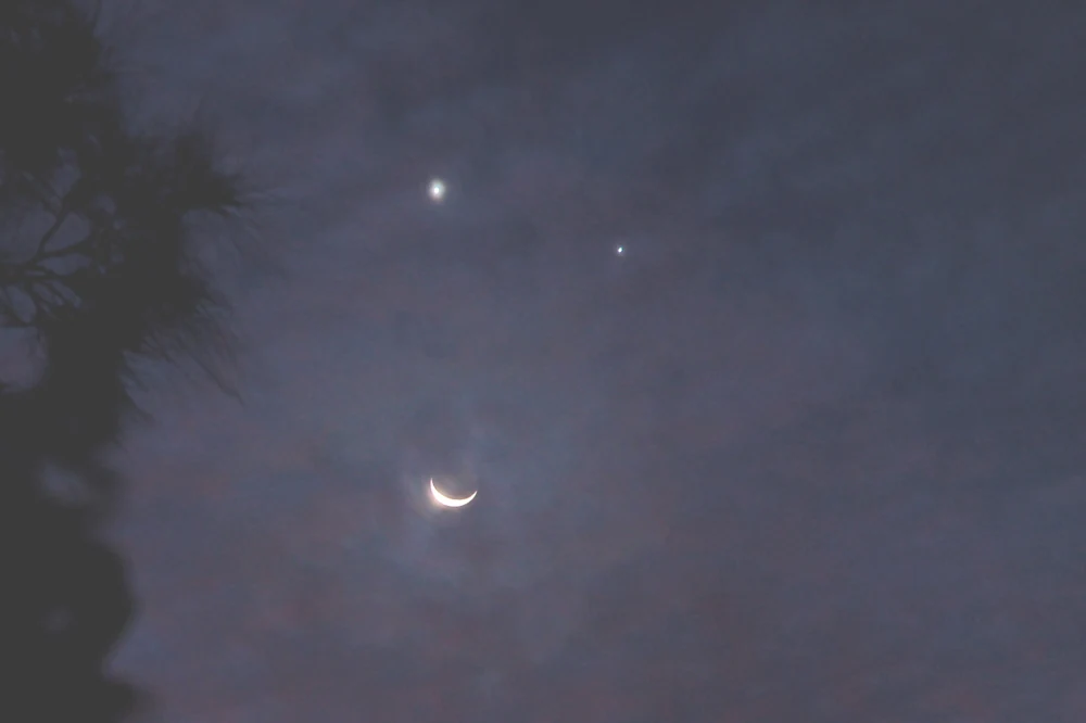 Venus, Moon, and Jupiter in conjunction above the horizon
