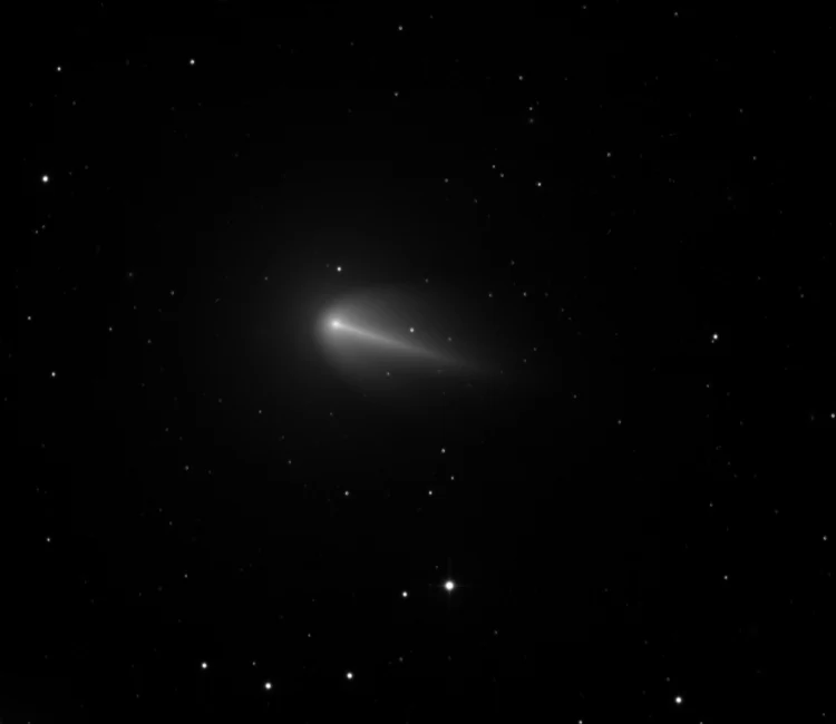 Telescopic image of comet 220P/McNaught showing a bright teardrop-shaped coma and a short tail against a field of stars