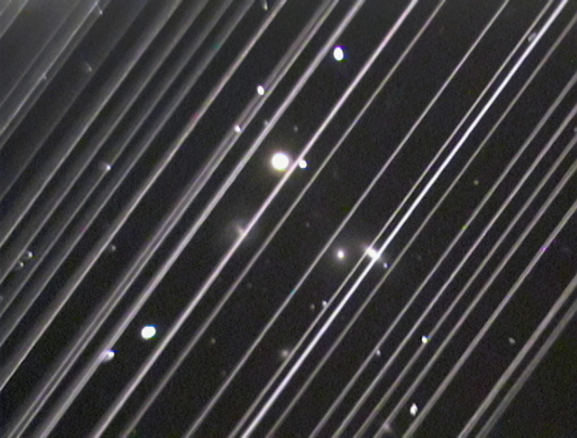 Diagonal white streaks left by more than 25 Starlink satellites crossing a Lowell Observatory telescope image of the NGC 5353/4 galaxy group, taken on 25 May 2019.